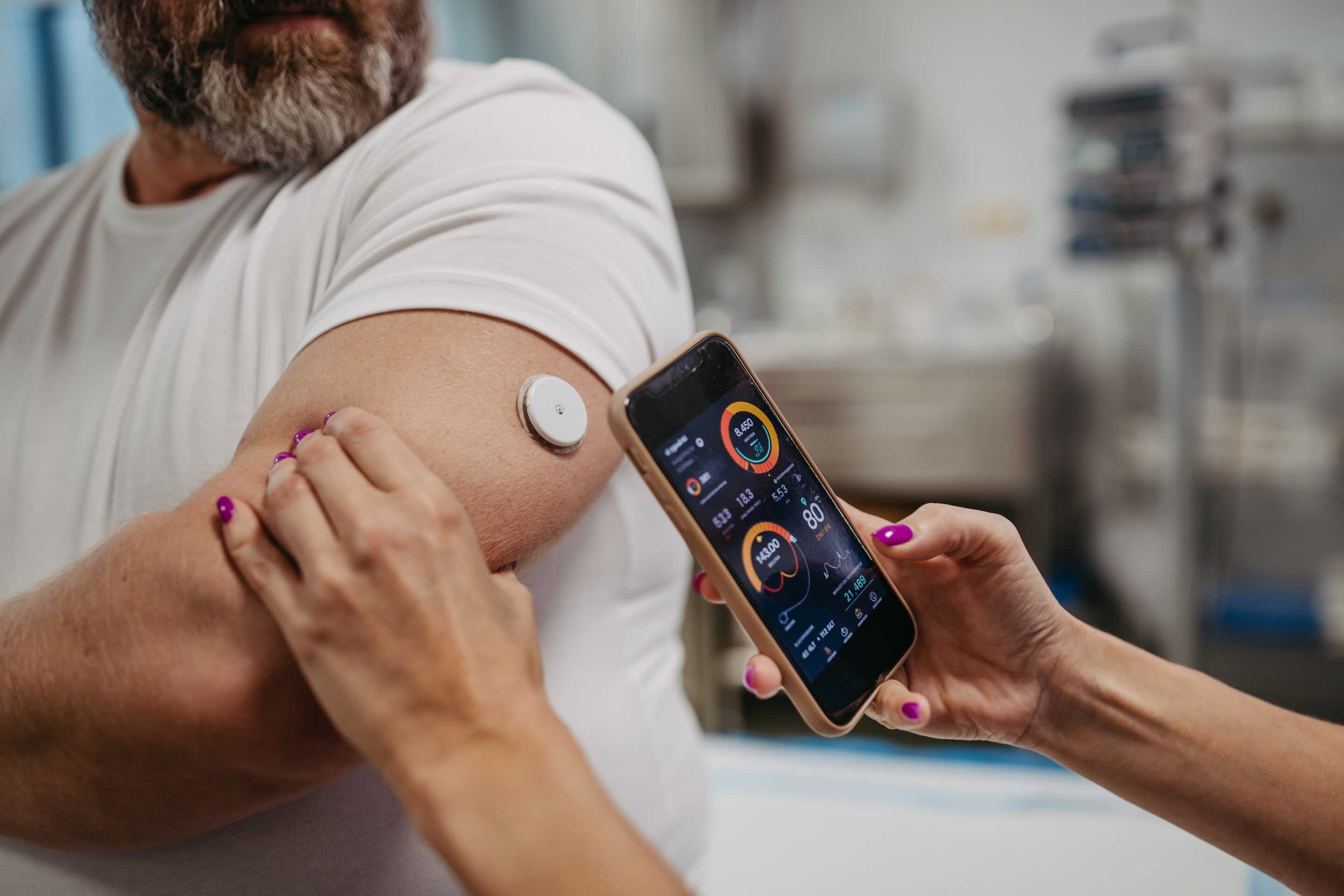 DoctorConnectingContinuousGlucoseMonitorWithSmartphoneToCheckBlood